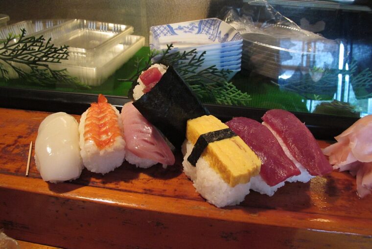 A close-up view of various pieces of sushi arranged on a wooden board, highlighting traditional Japanese culinary presentation.