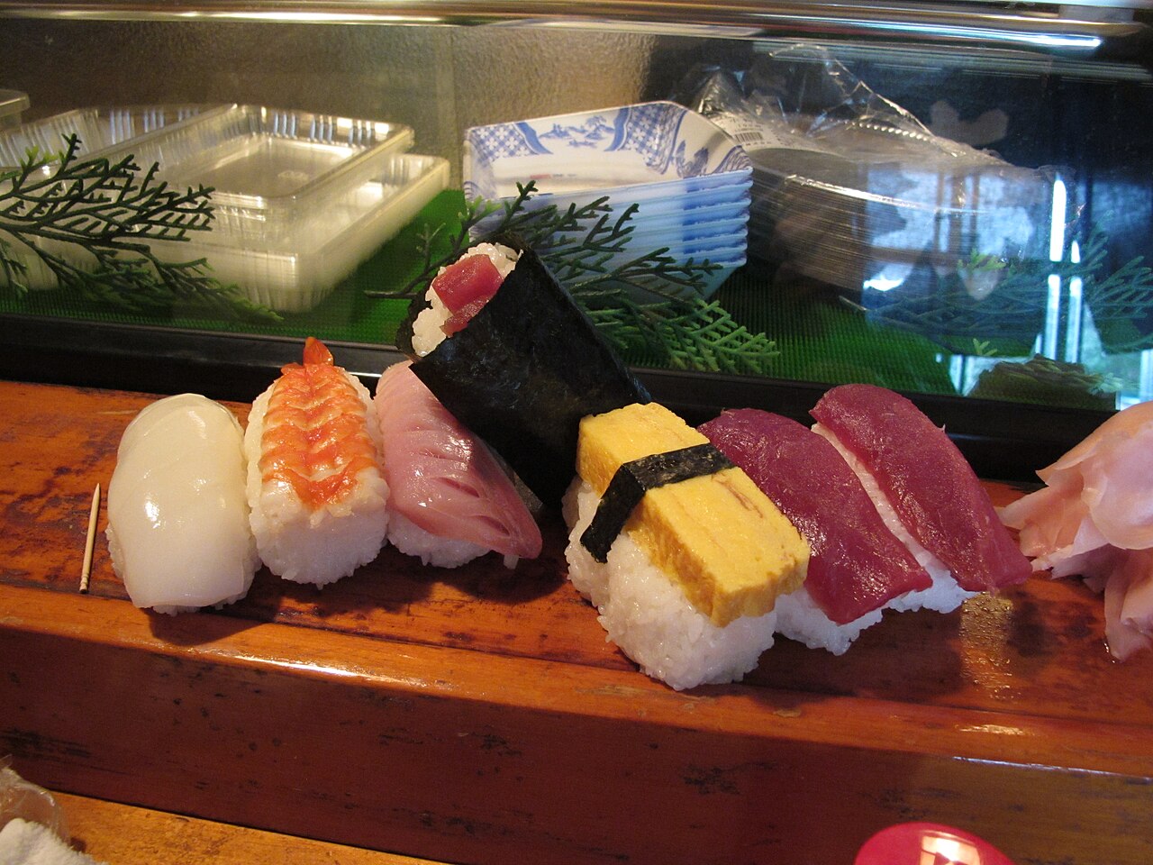 A close-up view of various pieces of sushi arranged on a wooden board, highlighting traditional Japanese culinary presentation.