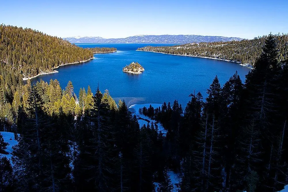 Emerald Bay and Fannette Island framed by pine forest and winter snow at Lake Tahoe